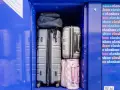 Luggage stored in a blue locker, including suitcases and bags.